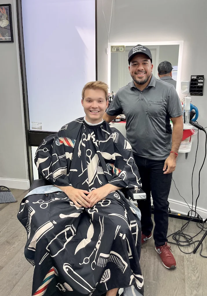 Smiling customer in the chair with his barber