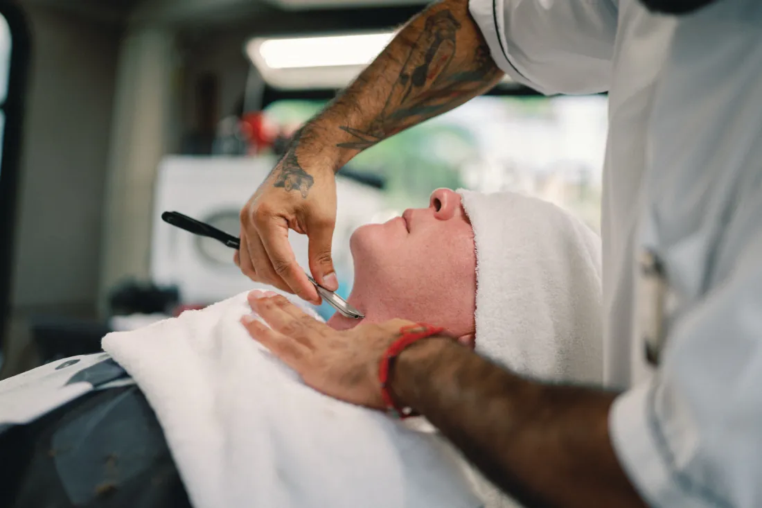 Barber shaving a client with a straight razor